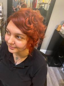 A woman with short, curly red hair